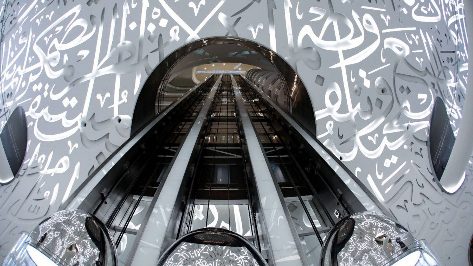 Visitors walking through a sunlit museum courtyard